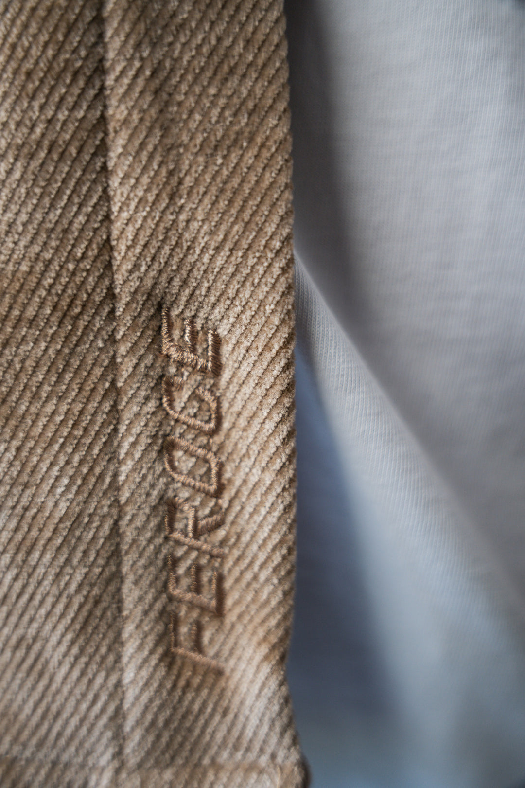 Détail chemise velours fin beige en coton, finition brodée.