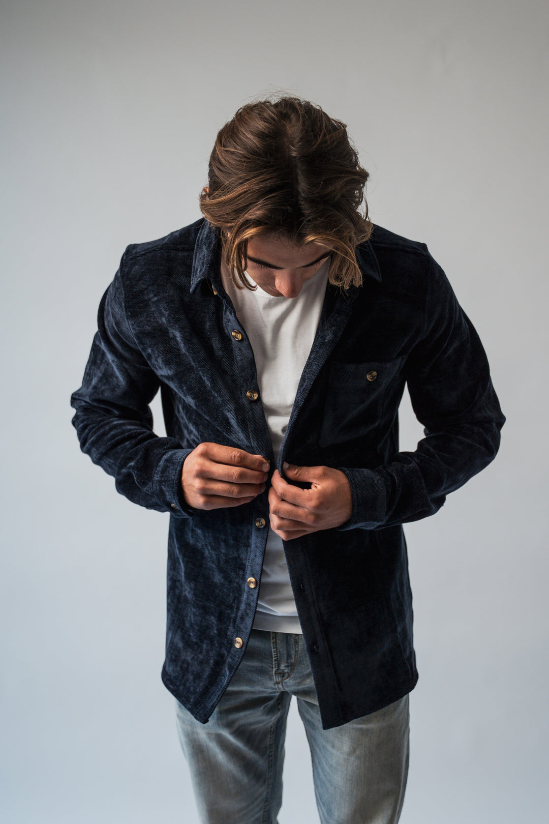 Chemise velours bleu marine portée boutonnée, look habillé hiver.