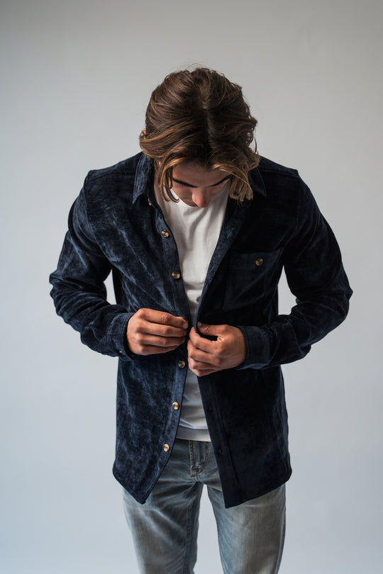 Chemise velours bleu marine portée boutonnée, look habillé hiver.