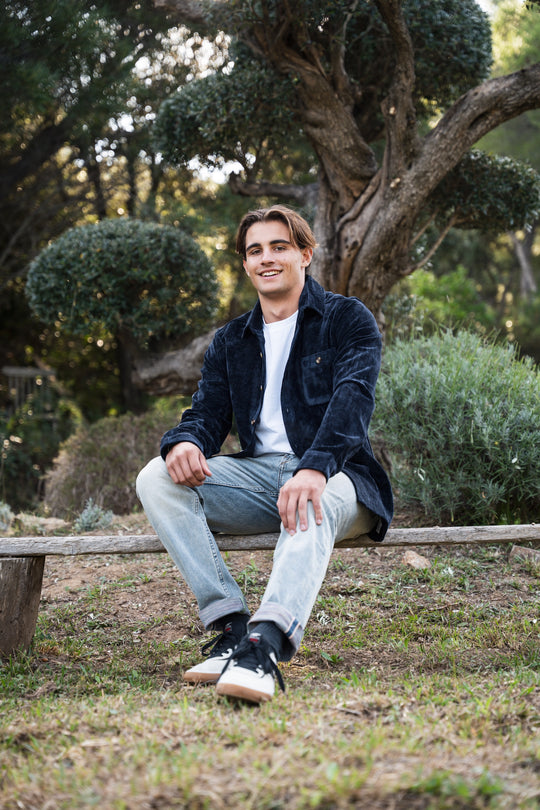 Chemise velours bleu marine portée en extérieur, style casual hiver.