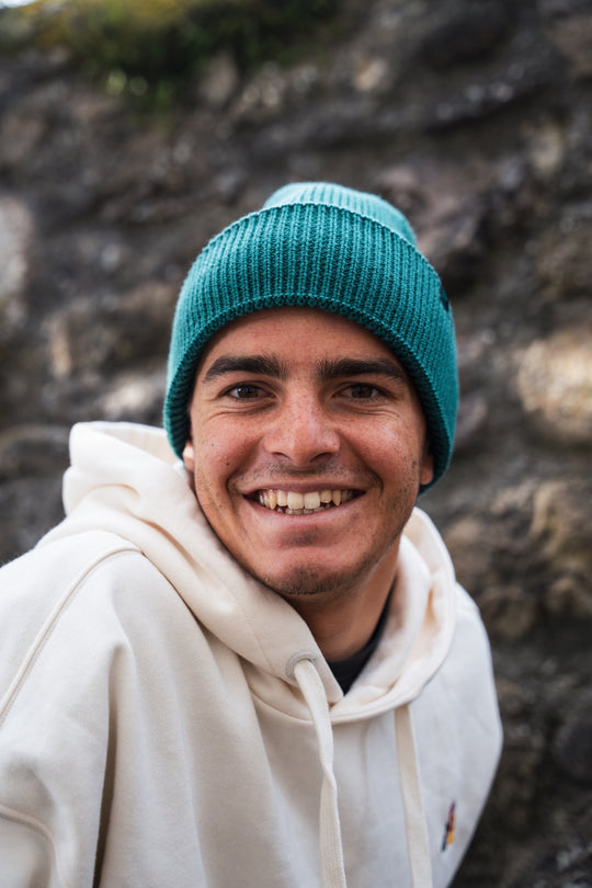 Bonnet à grosse maille MANASLU vert, porté par un homme vue de face en extérieur.