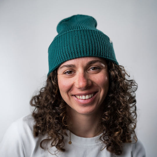 Bonnet à grosse maille MANASLU vert, porté par une femme vue de face en extérieur.